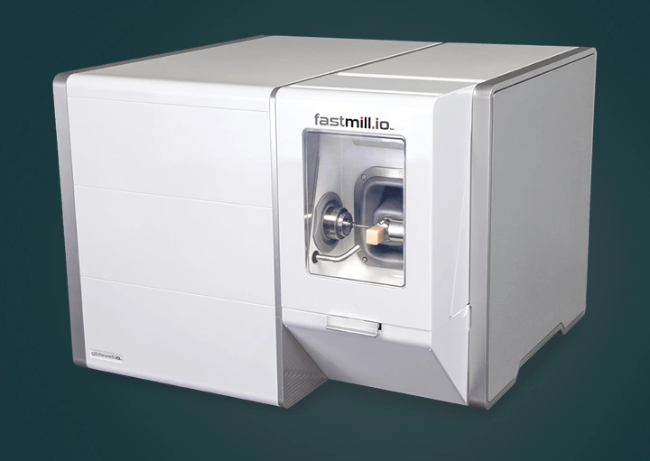 White dental laboratory equipment with control panel and display screen on green background.